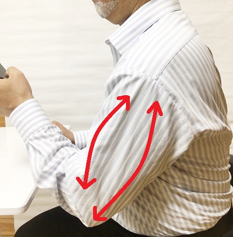 左手にスマホを持って操作する男性の肘から方にかけて矢印が力が入ってることを示している